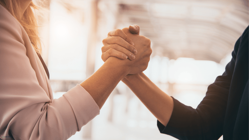 Two individuals shaking hands firmly, symbolizing the trust and cooperation essential in a business partnership.